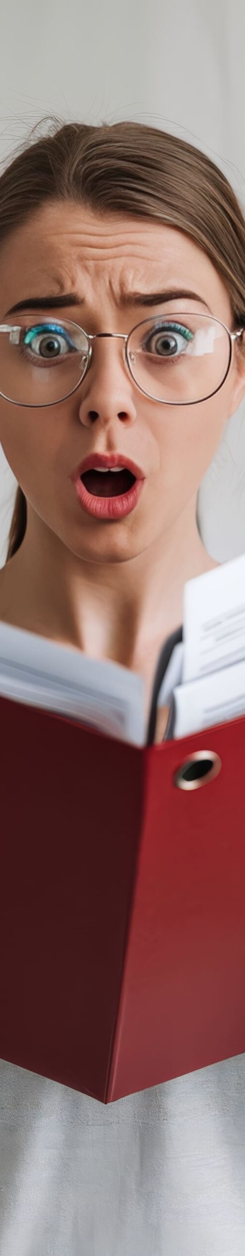 portrt-young-lady-eyeglasses-standing-with-open-red-folder-amazedly-looking-camera (1)